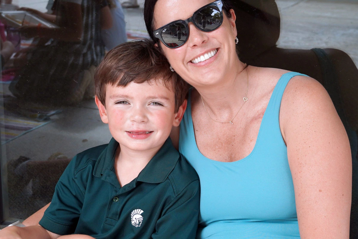 An Athens Academy student with an adult visitor on campus